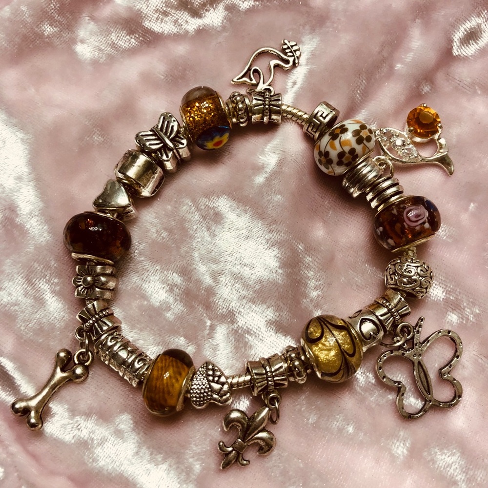 Charm bracelet with charms that is silver.